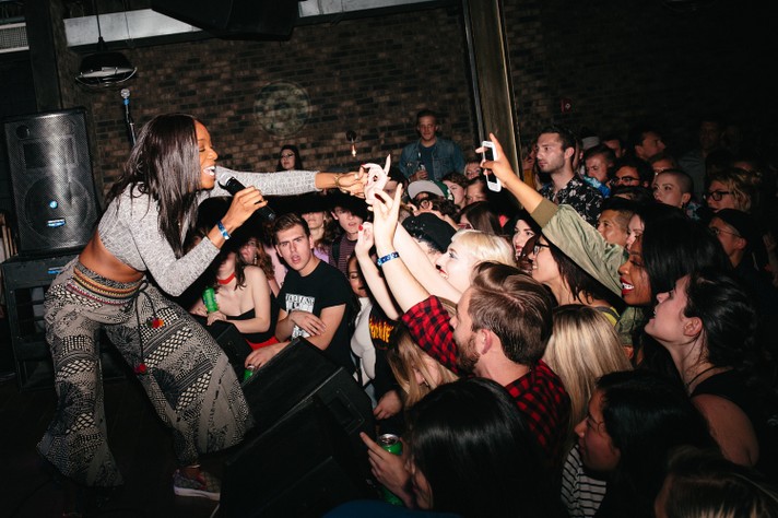 The artist Junglepussy reaches out to touch the hands of some fans in the crowd during their performance at Commonwealth during Sled Island 2016.