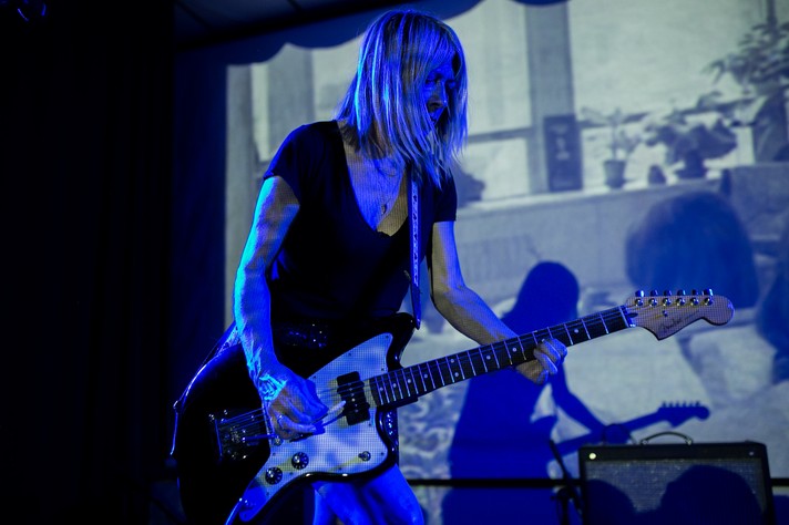 Kim Gordon of the duo Body/Head plays guitar is front of a screen projection while performing at the #1 Royal Canadian Legion during Sled Island 2015.
