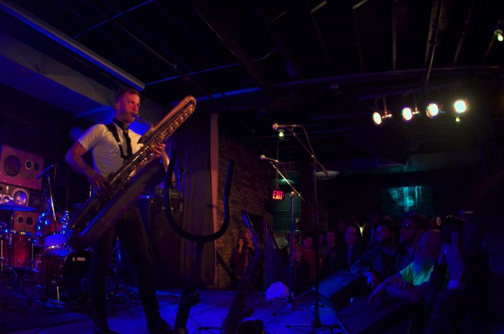 Musician Colin Stetson is seen playing a large saxophone while performing at Commonwealth Bar 7 Stage during Sled Island 2013.