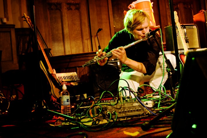 A member of the group Grizzly Bear crouches down and plays the flute during their performance at Central United Church for Sled Island 2008.