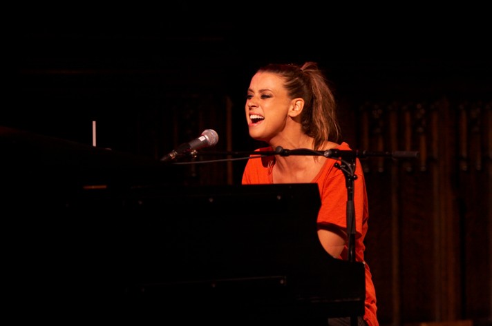 Artist Cat Power is seen singing and playing piano at Knox United Church during Sled Island 2007. She is seen wearing a red dress and sporting a pony tail.