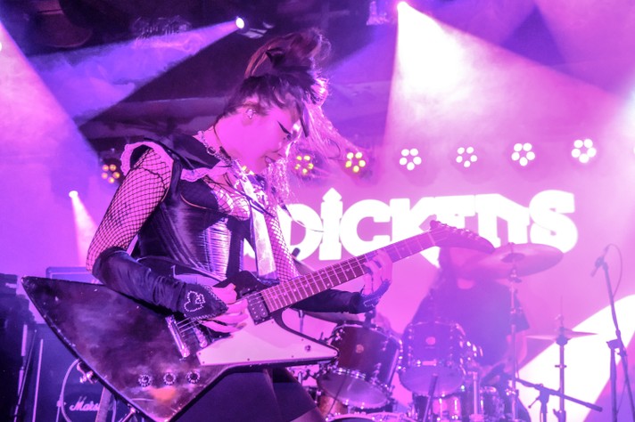 The artist SASAMI viciously plays guitar while bathed in pink light during their show at Dickens during Sled Island 2022.