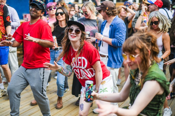 Audience members happily dance during a show at the Modern Love patio during Sled Island 2024.